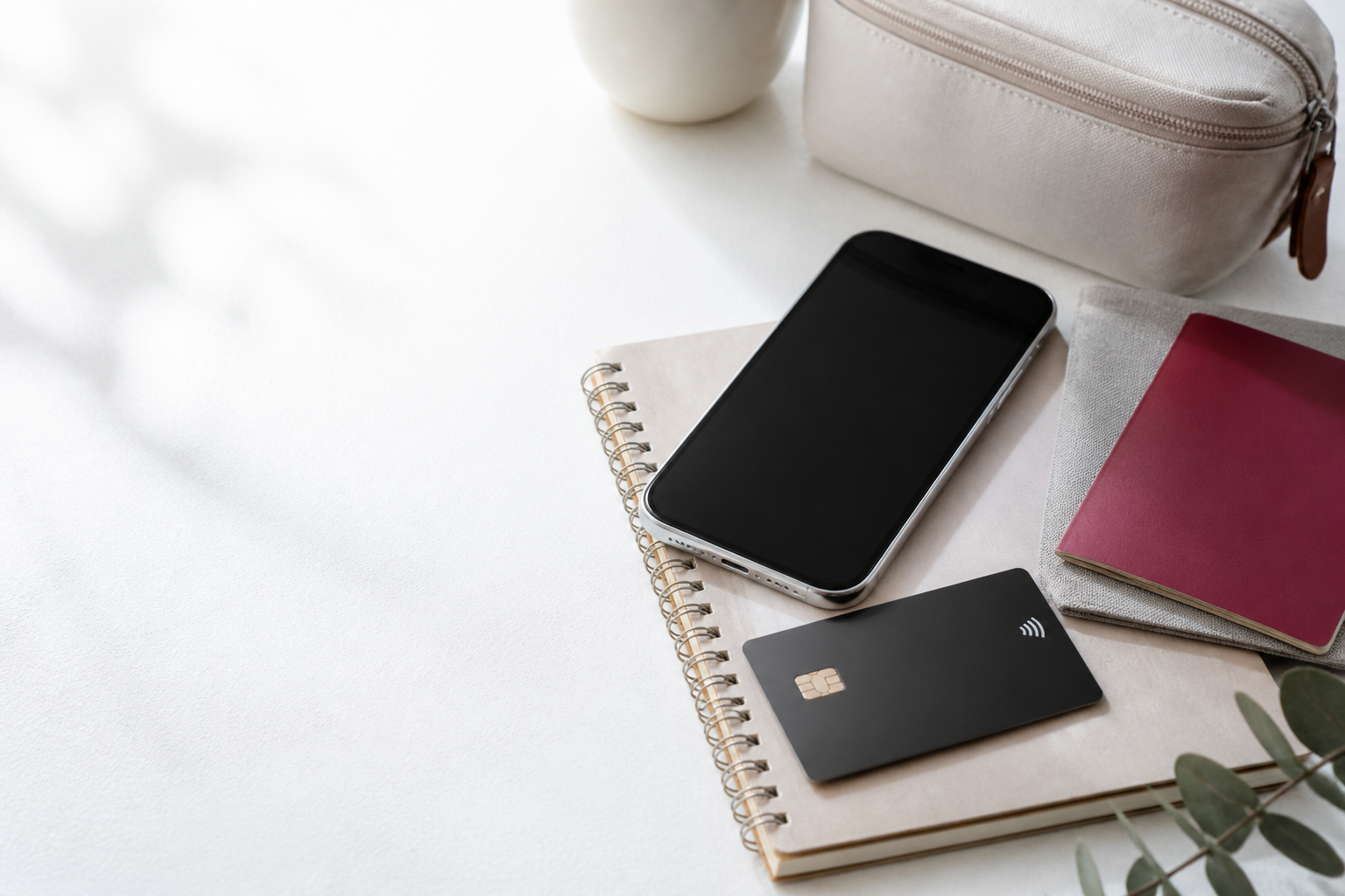 カード、スマートフォン、ノート、旅行用品を置いた机